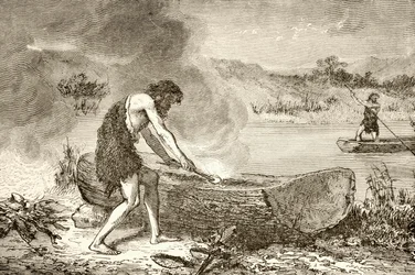 A Prehistoric Man Using Fire to Fashion a Canoe from a Log